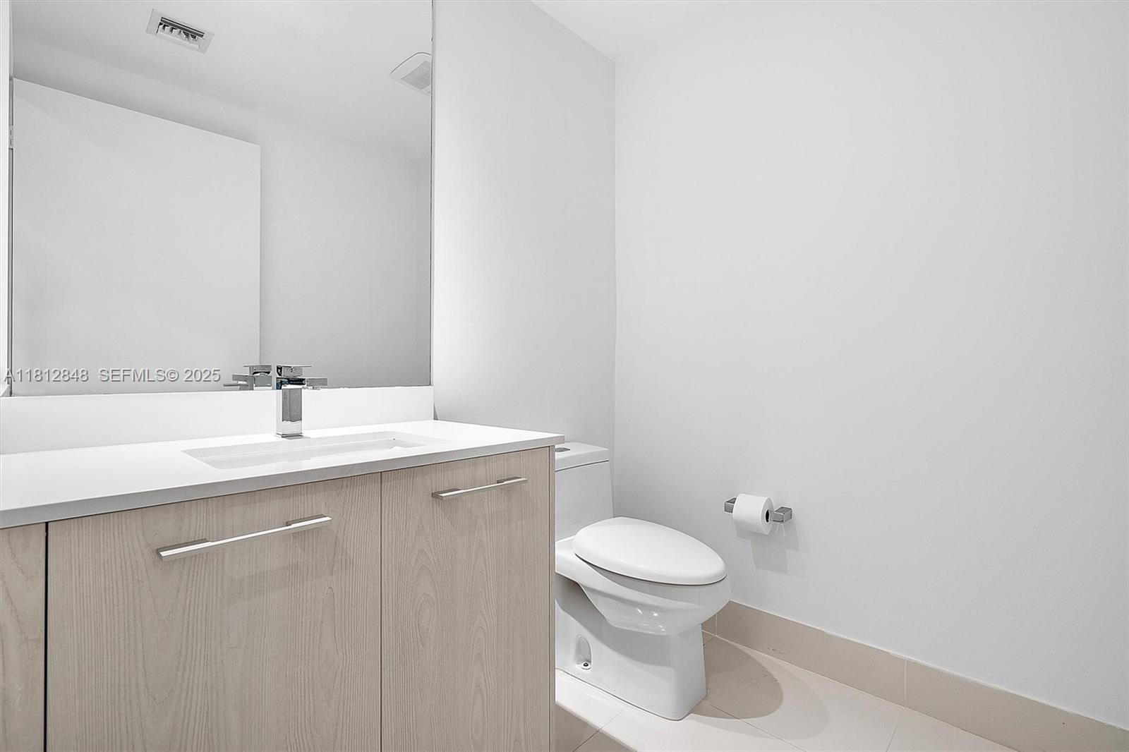 55 Southwest 9th Street, Unit 1510 Miami, FL 33130 - Photo 19 of 46 a bathroom with a sink a toilet and a mirror