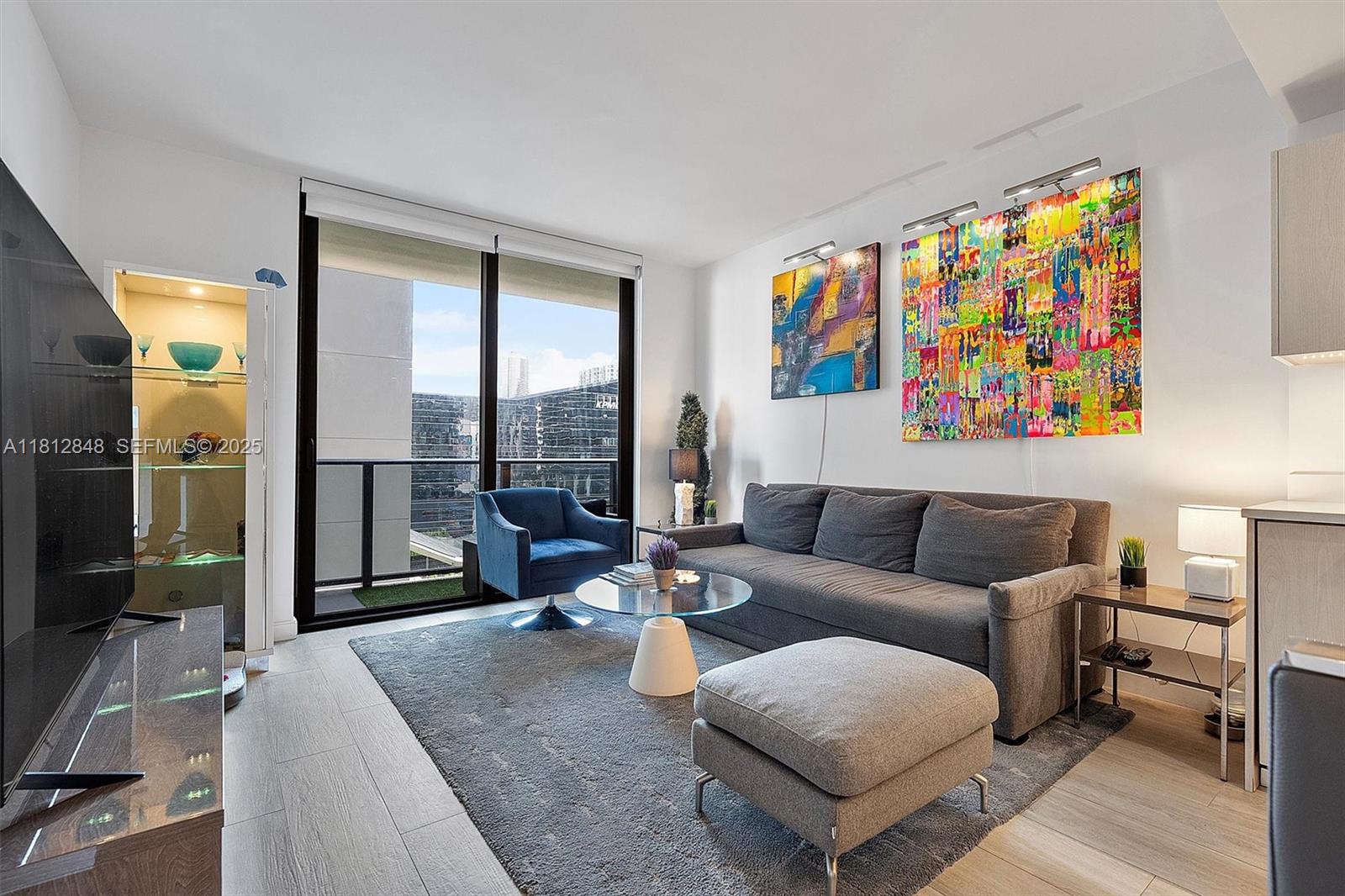 55 Southwest 9th Street, Unit 1510 Miami, FL 33130 - Photo 3 of 46 a living room with furniture and a floor to ceiling window