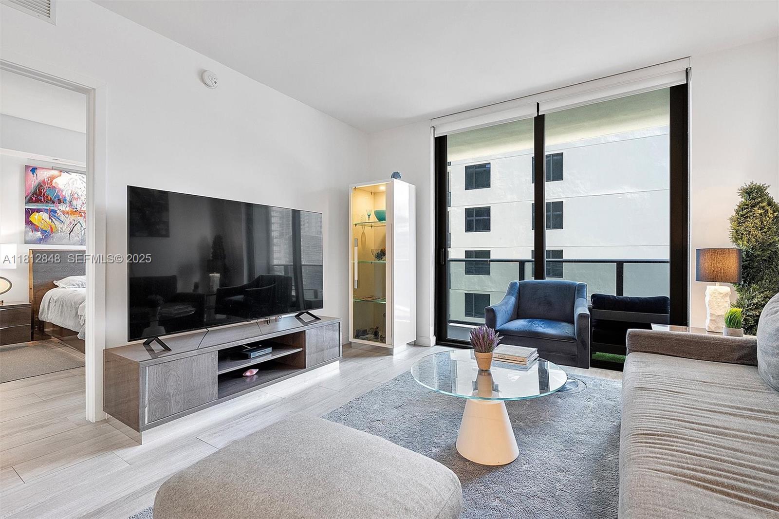 55 Southwest 9th Street, Unit 1510 Miami, FL 33130 - Photo 5 of 46 a living room with furniture and a flat screen tv