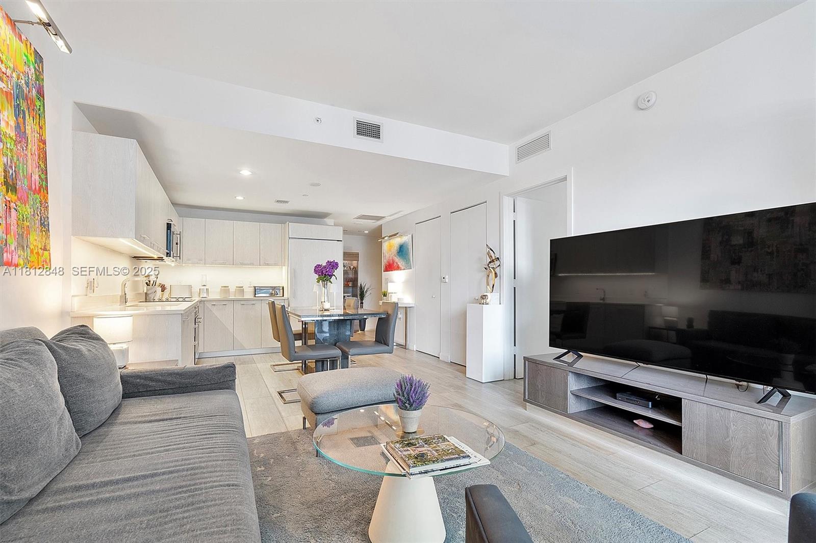 55 Southwest 9th Street, Unit 1510 Miami, FL 33130 - Photo 6 of 46 a living room with furniture and a flat screen tv