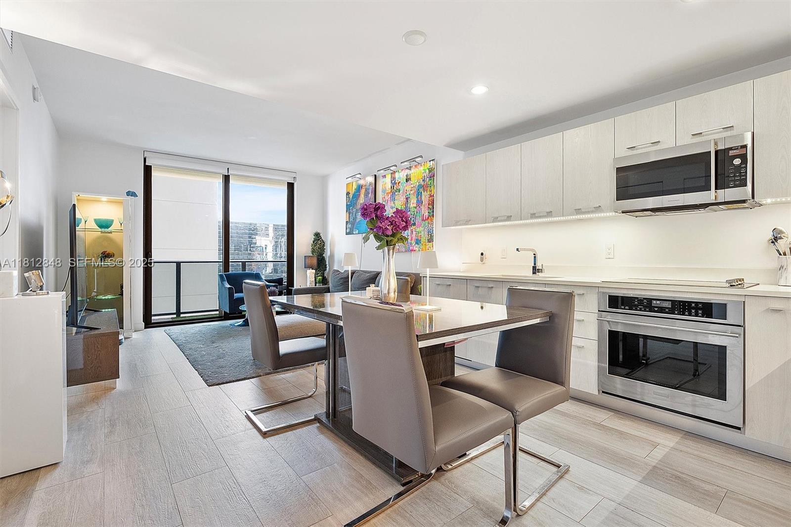 55 Southwest 9th Street, Unit 1510 Miami, FL 33130 - Photo 9 of 46 a kitchen with a stove a sink and a microwave