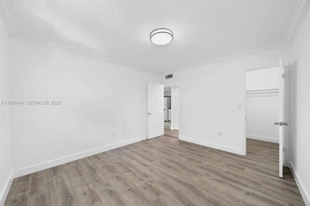 a view of a room with wooden floor and white walls