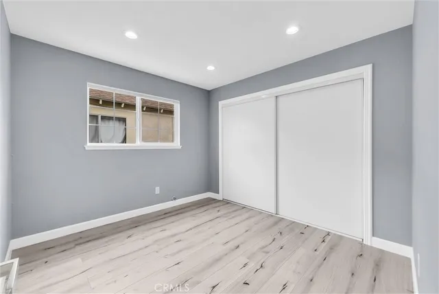 an empty room with wooden floor and a window