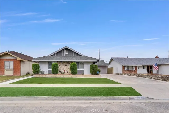 a front view of a house with a garden and yard