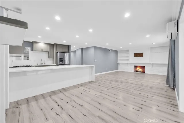 a large kitchen with stainless steel appliances kitchen island a large counter top and a refrigerator