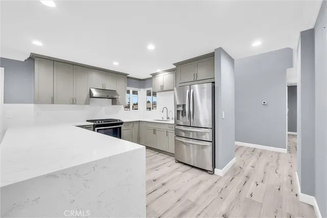 a kitchen with stainless steel appliances a refrigerator and a stove top oven