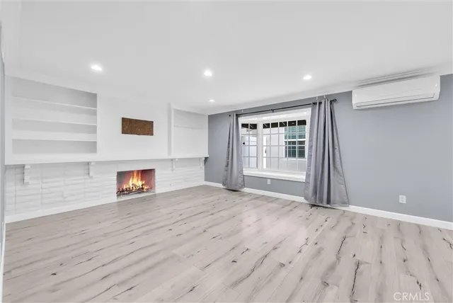 a view of empty room with wooden floor and fireplace
