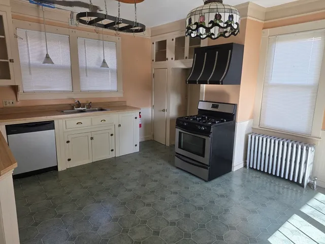 a kitchen with granite countertop a stove sink and cabinets