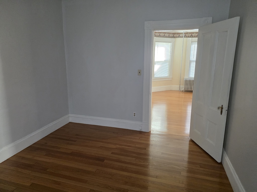 177 Highland Avenue, Unit 1 Fall River, MA 02720 - Photo 32 of 36 a view of an empty room with wooden floor and a window