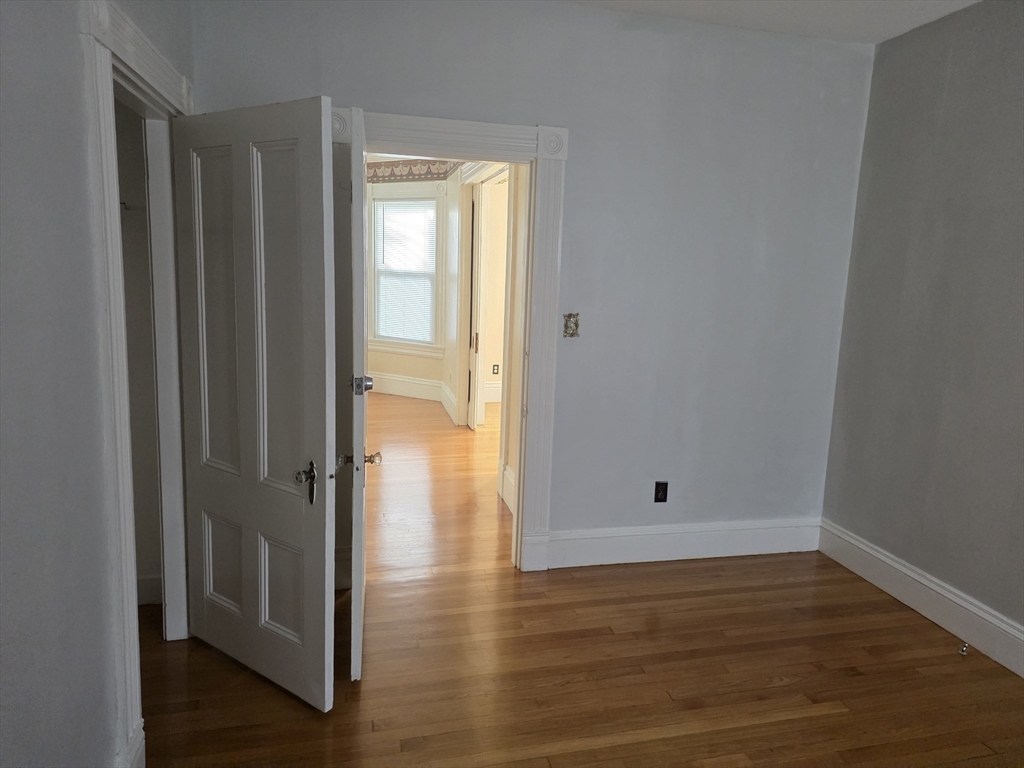 177 Highland Avenue, Unit 1 Fall River, MA 02720 - Photo 35 of 36 a view of an empty room with wooden floor and a window