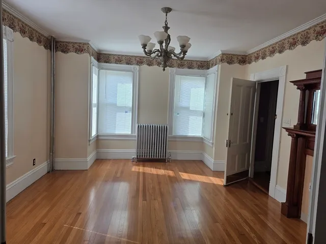 a view of a livingroom with wooden floor and a ceiling fan