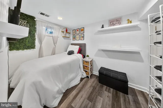 a bedroom with a bed and a refrigerator