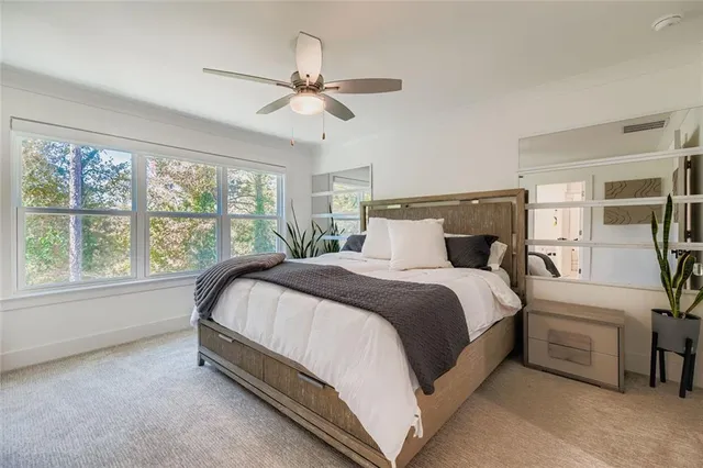 a large bed sitting in a bedroom next to a window