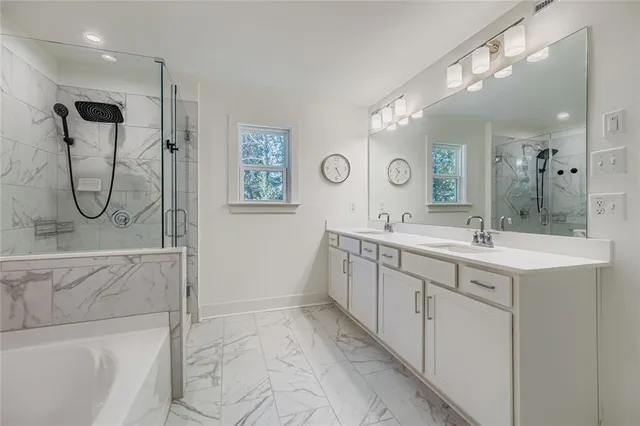 a spacious bathroom with a double vanity sink mirror and bathtub