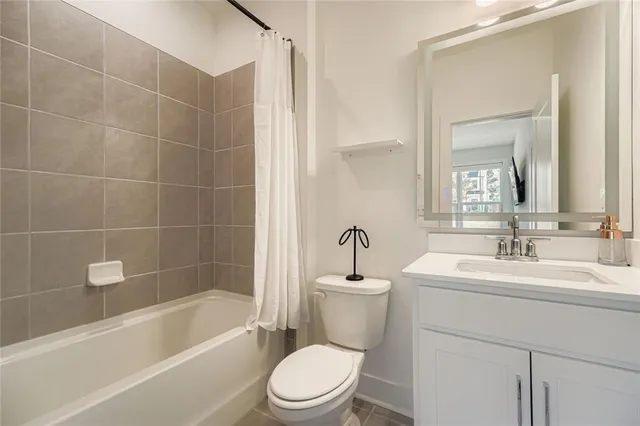 a bathroom with a bathtub shower sink vanity mirror and toilet
