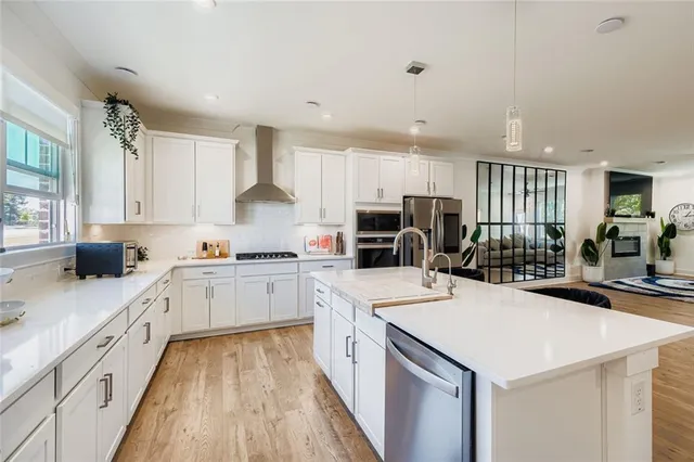 a kitchen with a sink a stove a refrigerator and white cabinets