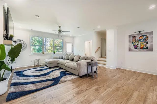 a living room with furniture a window and a table with wooden floor