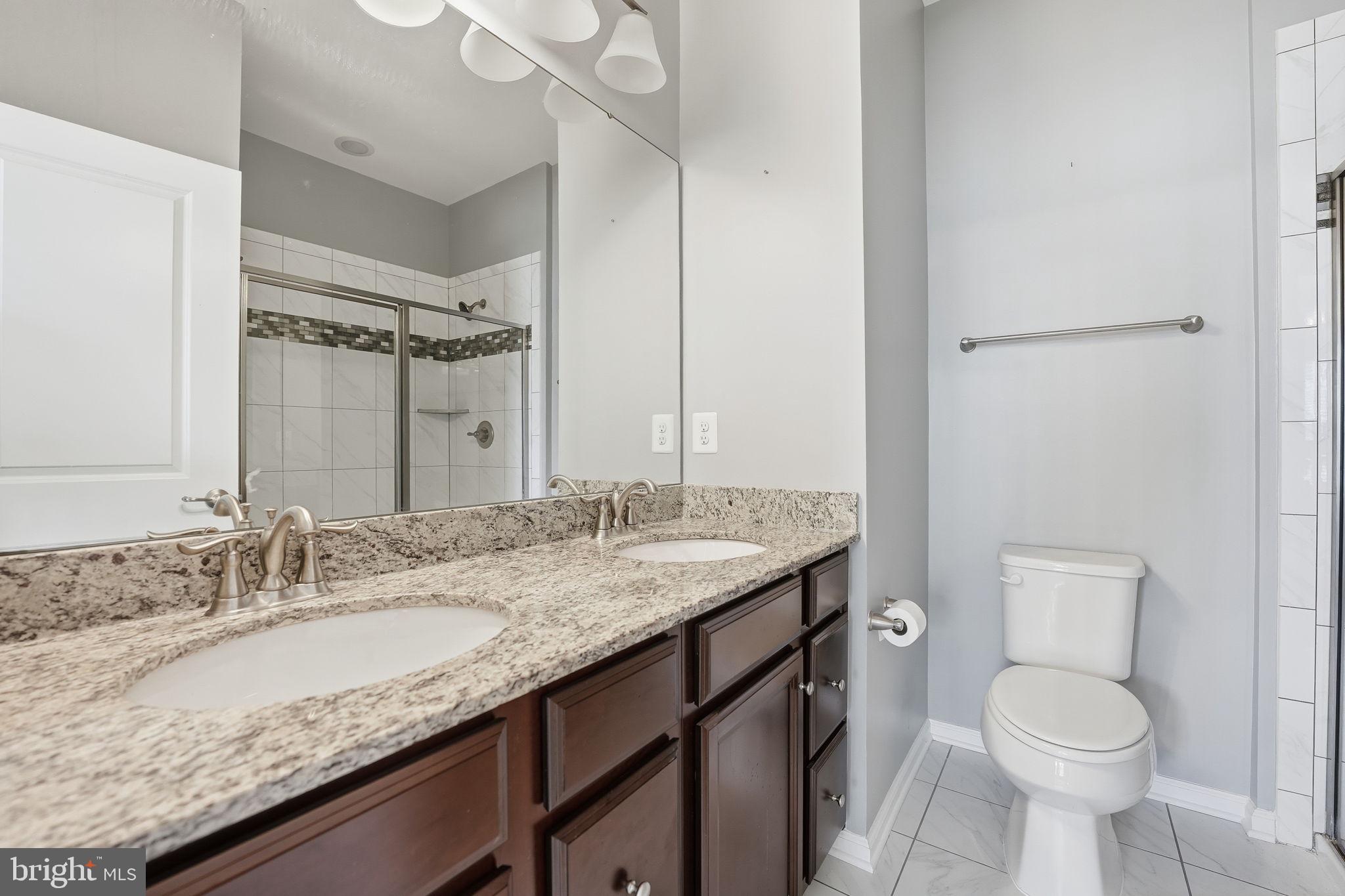 14619 Featherstone Gate Drive Woodbridge, VA 22191 - Photo 15 of 20 a bathroom with a granite countertop sink a toilet and a mirror