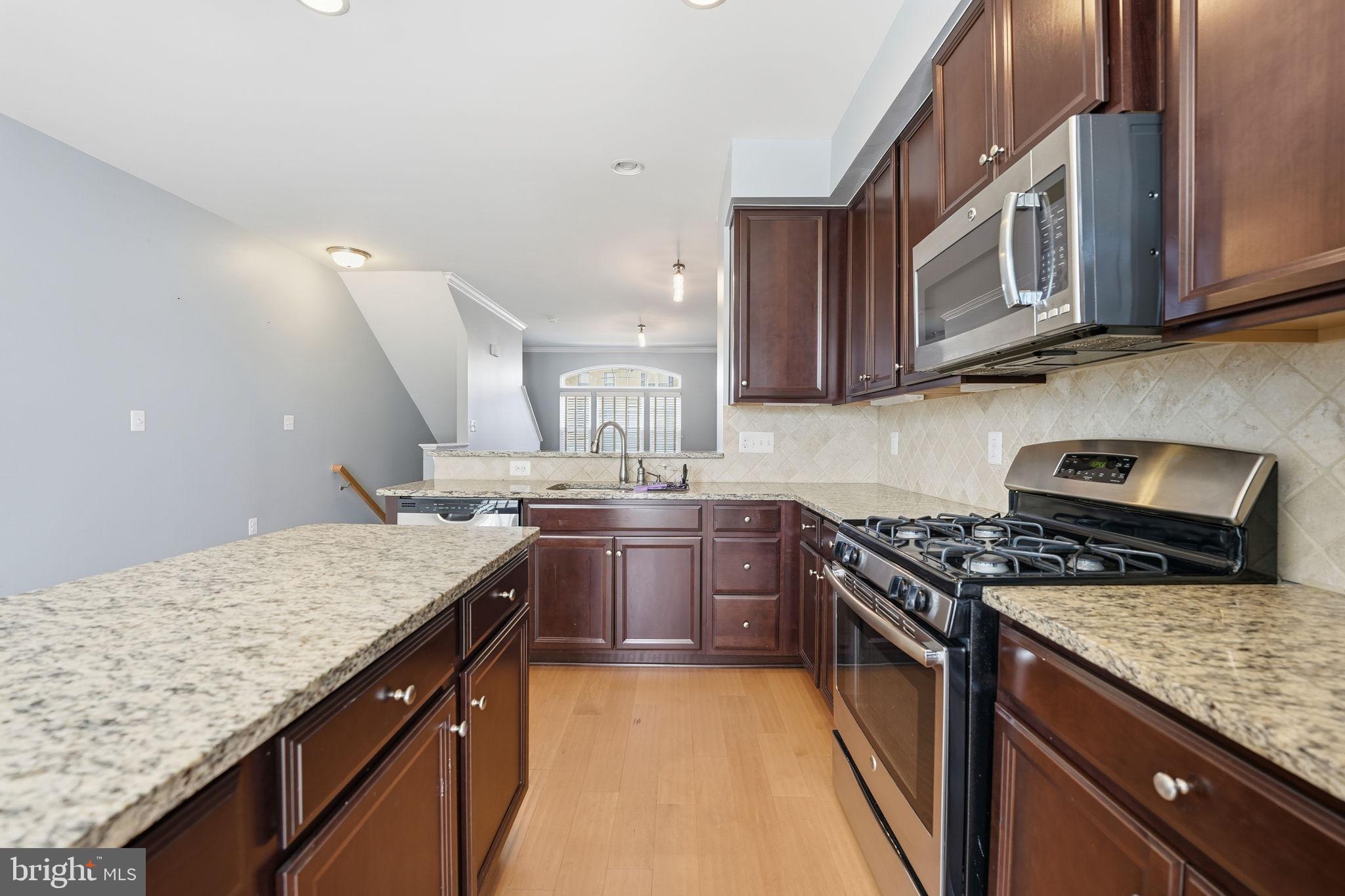 14619 Featherstone Gate Drive Woodbridge, VA 22191 - Photo 7 of 20 a kitchen with stainless steel appliances granite countertop a stove a sink and a microwave