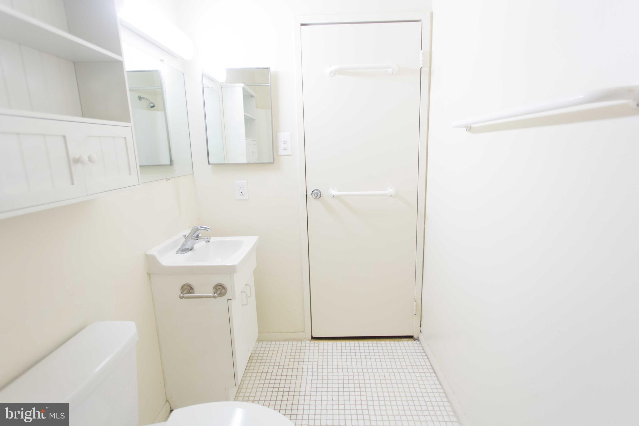 2031-8 South Street, Unit 123 Philadelphia, PA 19146 - Photo 28 of 31 a bathroom with a sink a toilet and mirror