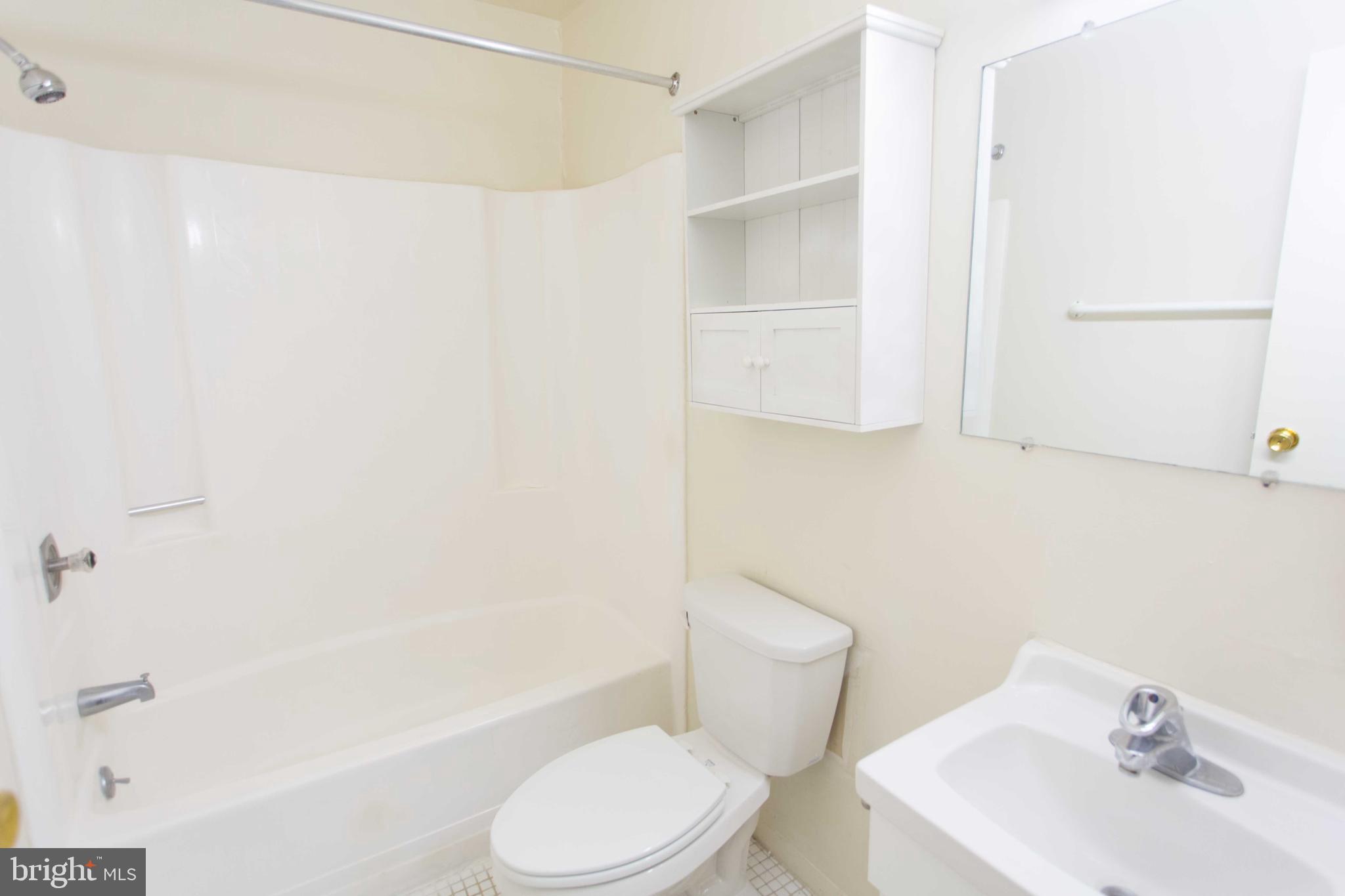 2031-8 South Street, Unit 123 Philadelphia, PA 19146 - Photo 29 of 31 a white toilet sitting next to a bathroom sink