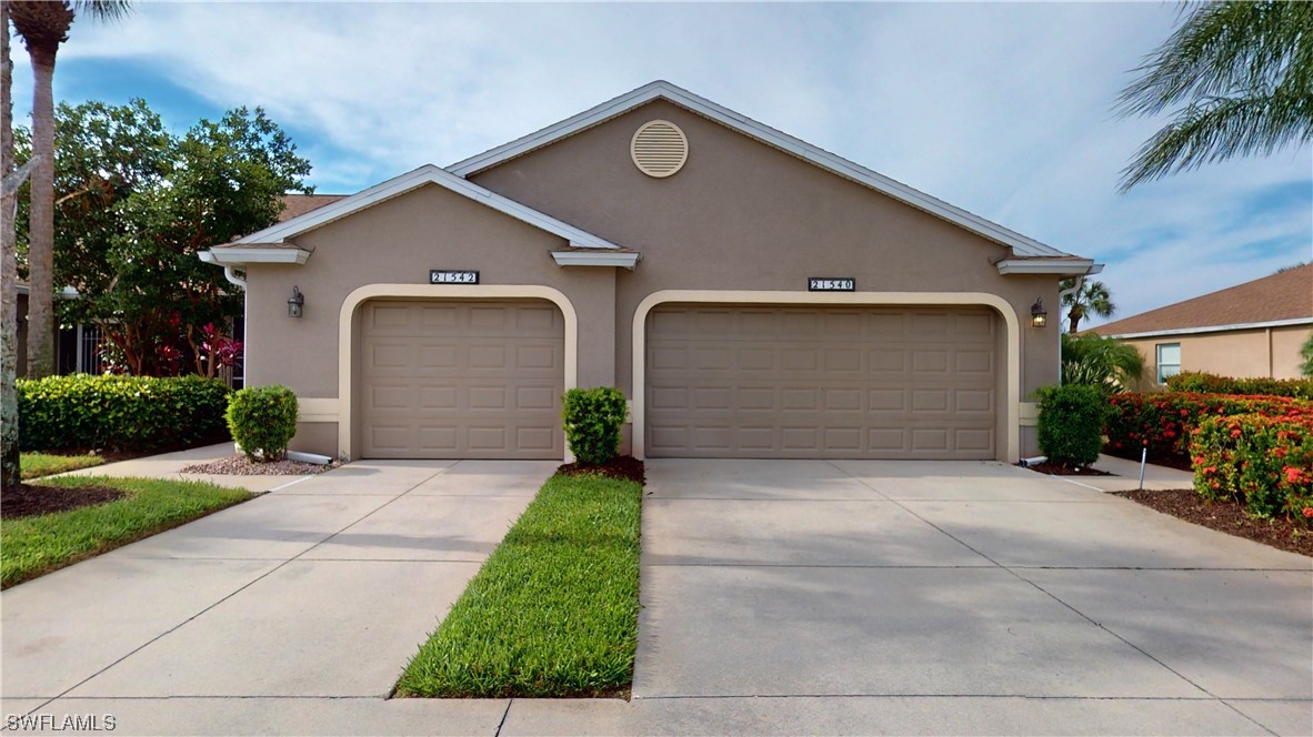 21540 Portrush Run Estero, FL 33928 - Photo 28 of 32 a front view of a house with a yard and garage