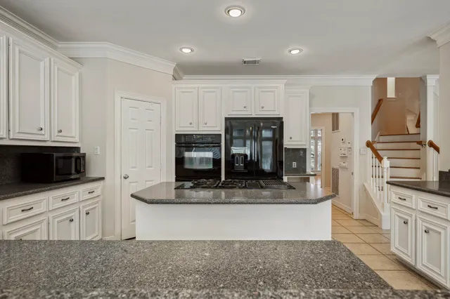 a kitchen with stainless steel appliances kitchen island granite countertop a stove a sink and a microwave