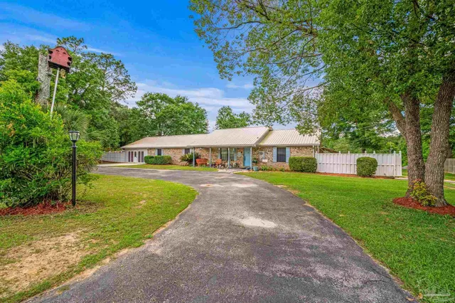 a front view of a house with yard and green space