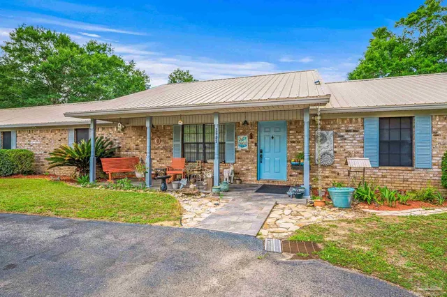 a view of a house with backyard porch and sitting area