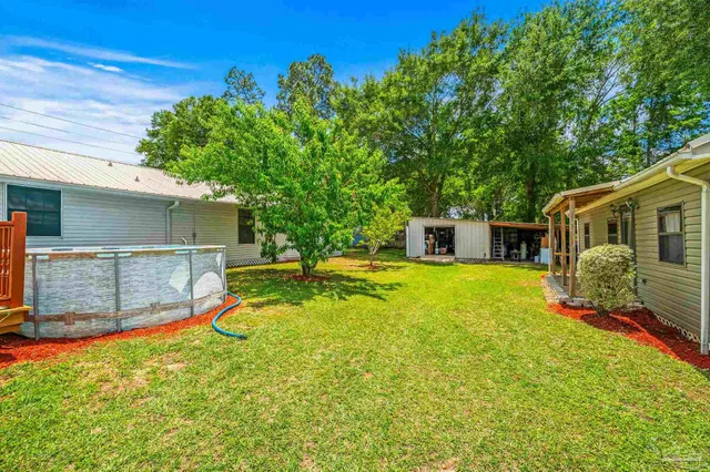 a view of a house with a yard and large tree