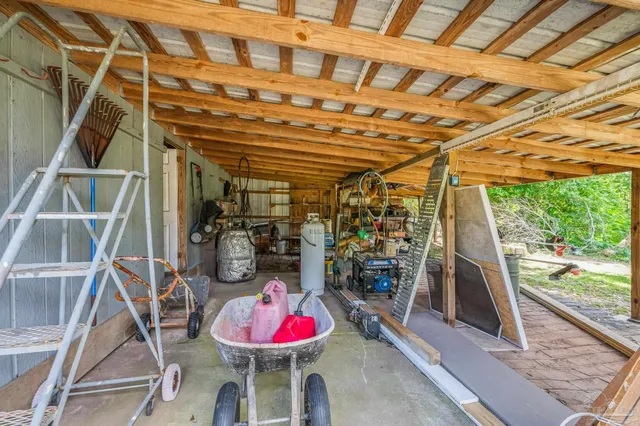 an empty room with windows fan and a chandelier fan