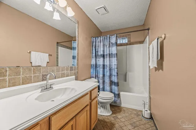 a bathroom with a sink toilet double vanity and shower
