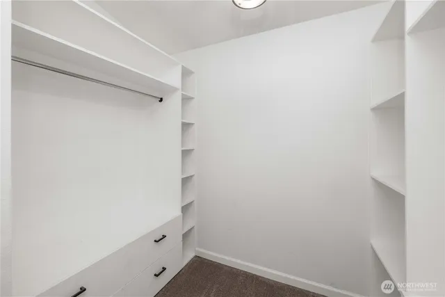 a view of walk in closet with empty racks