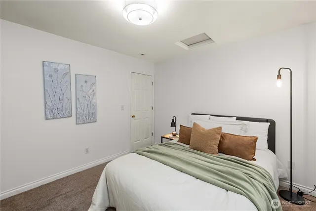 a bedroom with a bed and painting on the wall