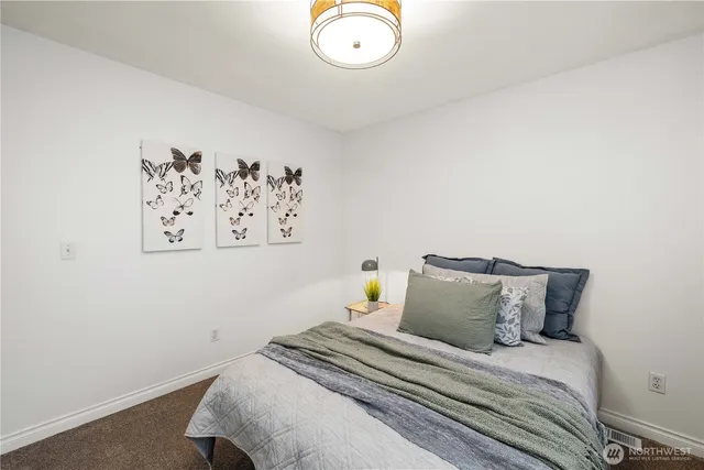 a bedroom with a bed and a wall painting