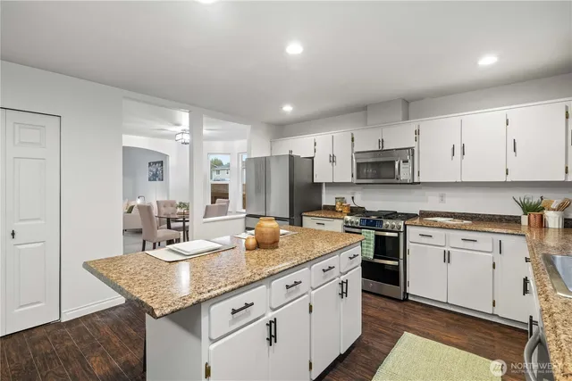 a kitchen with stainless steel appliances granite countertop a sink stove and cabinets