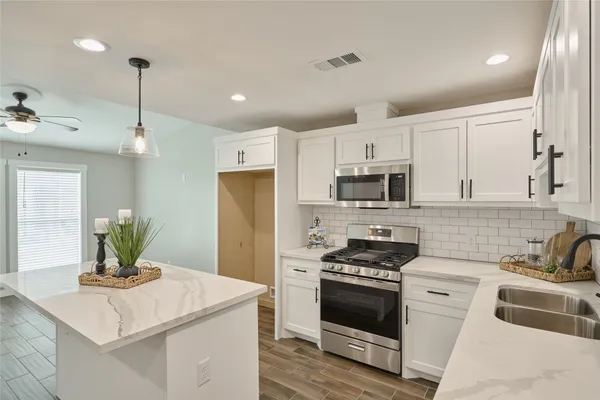 a kitchen with a stove a sink and a refrigerator