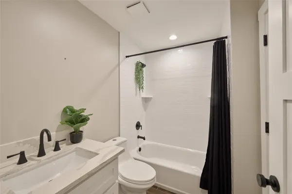 a bathroom with a granite countertop sink toilet a large mirror a bathtub and shower