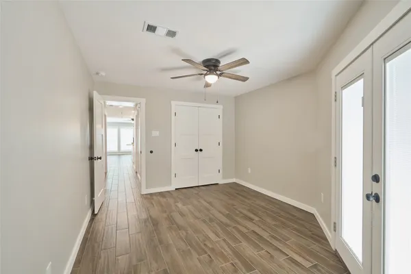 a view of a room with wooden floor and a ceiling fan