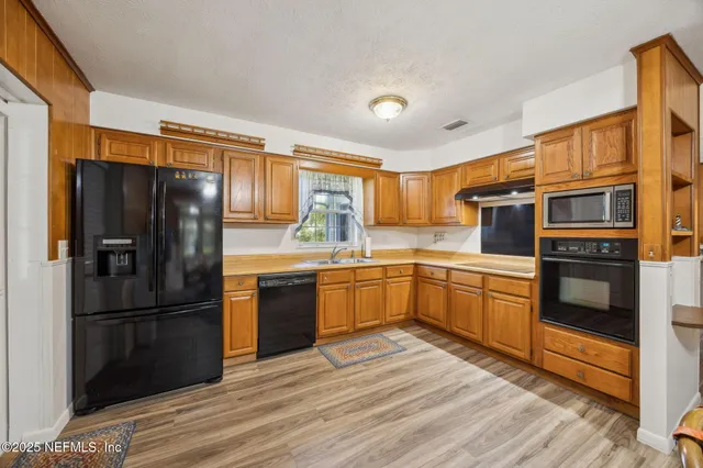 a bedroom with a bed a chandelier and a mirror on dresser