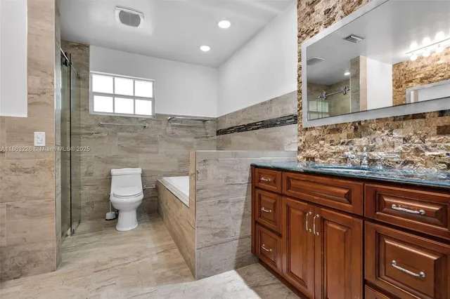 a bathroom with a toilet a sink and mirror