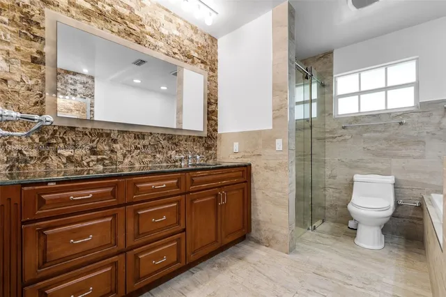 a bathroom with a sink a toilet and mirror