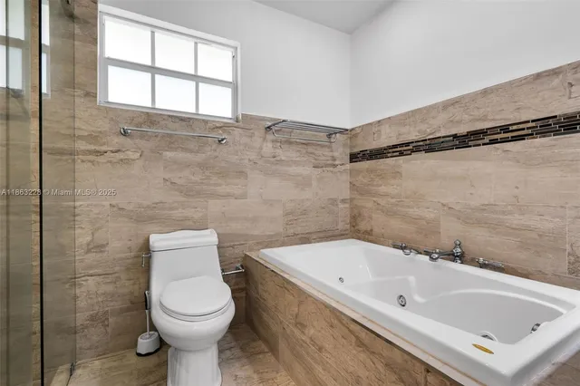 a bathroom with a white bath tub a toilet and a sink