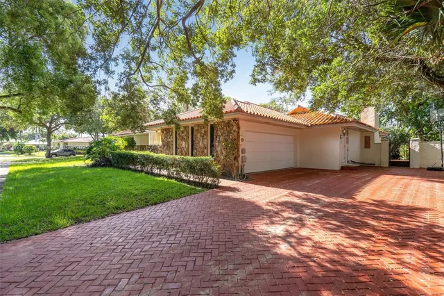 a view of a house with a yard and a large tree