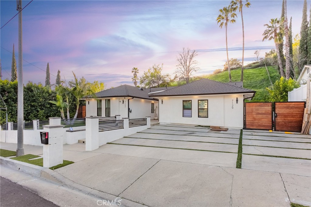 a view of house with yard and sitting area