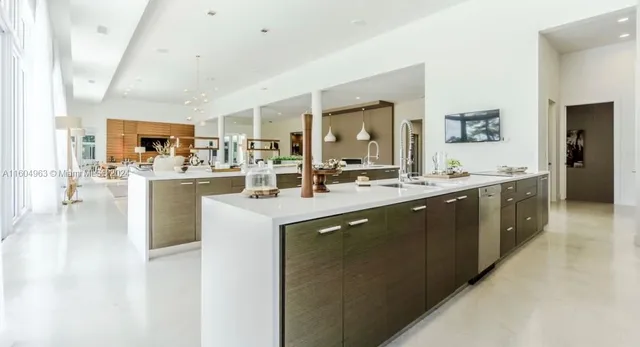 a view of a kitchen with kitchen island granite countertop a large window and living room