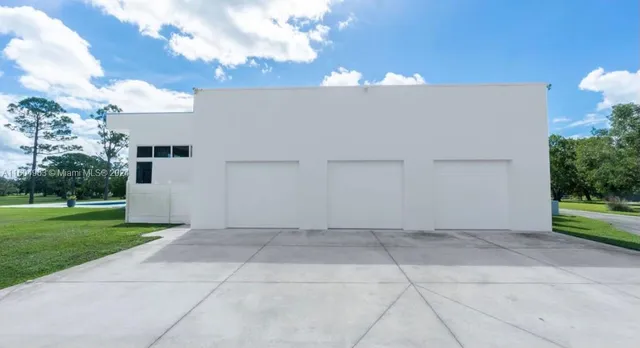 a view of a patio with a table chairs and a small yard