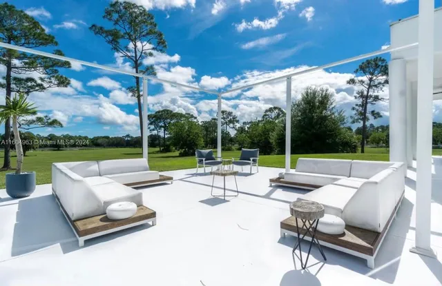 a view of a house with swimming pool and sitting area