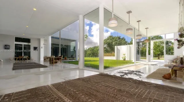 a living room with furniture floor to ceiling windows and a floor to ceiling window