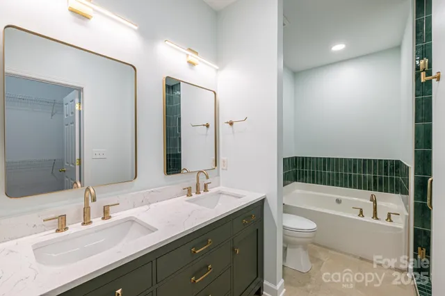 a bathroom with a sink vanity granite toilet tub and shower